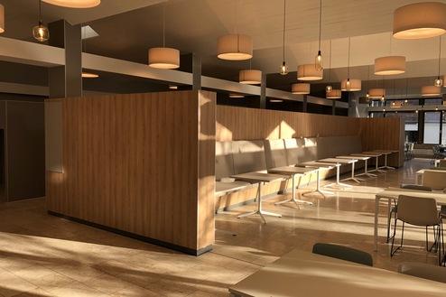 Individuelle Raumtrennung und Sitzbereich von Tischlerei Krogull Moderner Sitzbereich mit maßgefertigter Holz-Raumtrennung und integriertem Beleuchtungskonzept für eine stilvolle Atmosphäre.