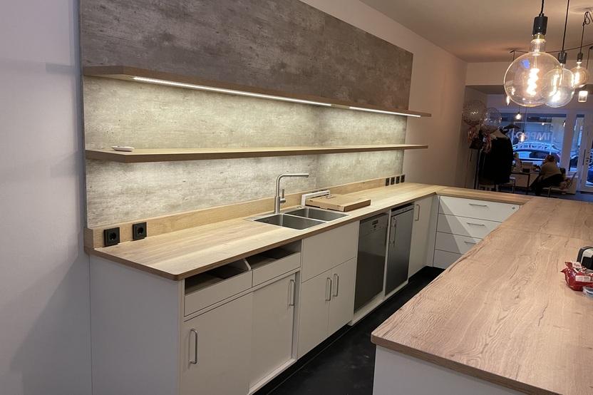 Maßgefertigte Küchenzeile mit Holzarbeitsplatten von Tischlerei Krogull Stilvolle Küchenzeile mit Holzarbeitsplatten, offenen Regalen und integrierter Beleuchtung in modernem Design.