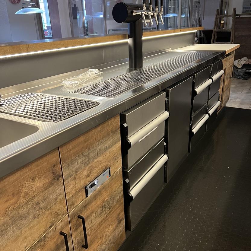 Edelstahl-Theke mit Zapfanlage von Tischlerei Krogull Professionelle Theke mit Edelstahl-Arbeitsfläche, integrierter Zapfanlage und Holzfronten.