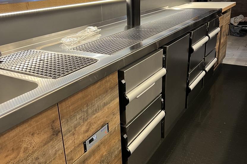 Edelstahl-Theke mit Zapfanlage von Tischlerei Krogull Professionelle Theke mit Edelstahl-Arbeitsfläche, integrierter Zapfanlage und Holzfronten.