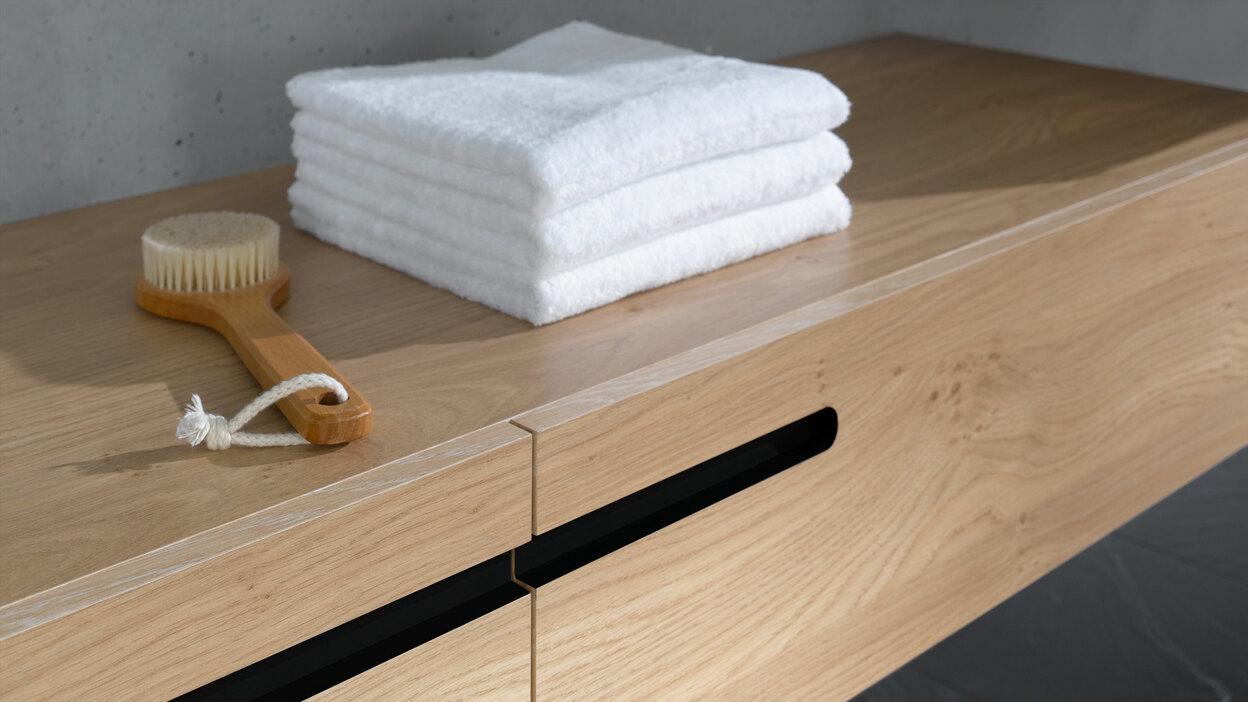 Detailaufnahme eines Waschtischunterschrankes aus Massivholz Detailaufnahme eines schmalen Waschtischunterschrankes aus Massivholz mit eingelassenen Griffen