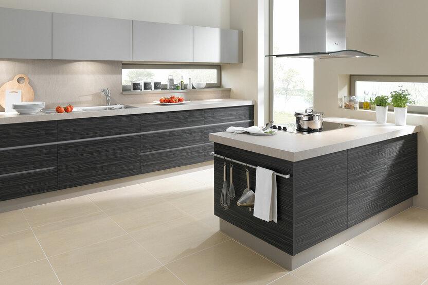 Impression einer Küchengestaltung mit Kochinsel mit Edelstahlabzug und dunklen Fronten