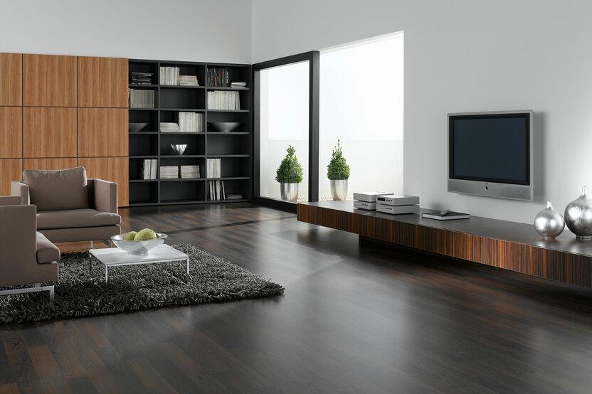 Wohnraumimpression mit dunklem Mobiliar Wohnraumimpression mit verschieden dunklen Holzoberflächen für Einbauschrank, Sideboard und Bodenbelag