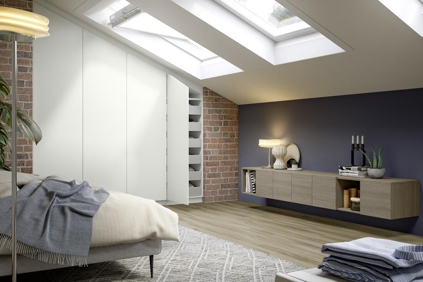 Ein großzügiger, weißer Schrank nach Maß nutzt geschickt die Schrägen des Dachgeschosses für optimalen Stauraum in diesem gemütlichen Schlafzimmer.